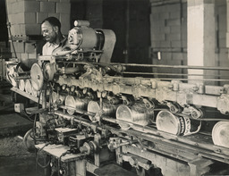 Man at work along line of sealed cans, ca. 1950s.