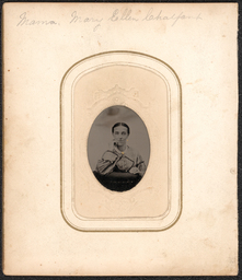Tintype in case. Photograph of a woman leaning against a piece of furniture. Her jewelry has been colored with gold. Above the tintype in pencil the subject is identified as: "Mama, Mary Ellen Chalfant". The tintype is part of an album of Cartes de visite of the Chalfant family.