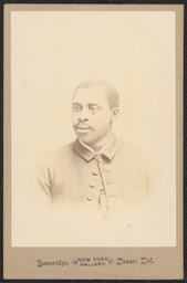 Photograph of a man from the mid chest up. He is wearing a coat with only the top button done. An ink stamp below the image reads: "Leveridge, New York Gallery, Dover, Del.".