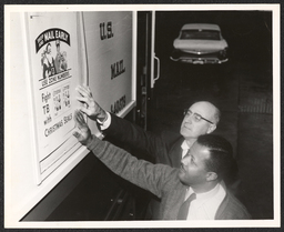 Two men examining a Christmas seals poster, undated