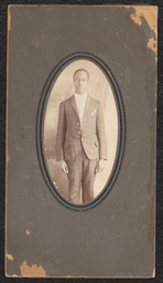 Photograph of a man wearing a plaid suit mounted on dark gray board. Embossed under the photograph is "A.N. Sanborn 404 Market St. Wilmington, Del.".