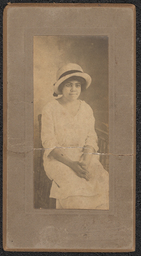 Photograph of a woman wearing a white dress and white hat mounted on a gray board. Embossed beneath the photograph is "A.N. Sanborn 404 Market Street, Wilmington, Del.".