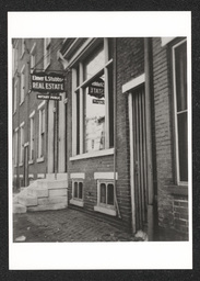 Exterior side view of Elmer E. Stubbs Inc. Real Estate sign and stoop