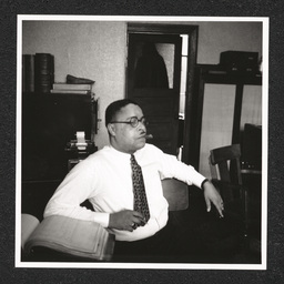 Elmer E. Stubbs poses at his desk with a cigar