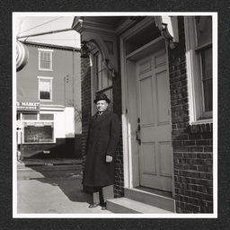 A man stands at the door of the Edward LeMay Gray Funeral Home