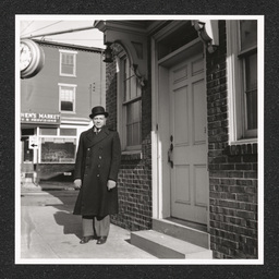 A man stands at the door to the Edward LeMay Gray Funeral Home