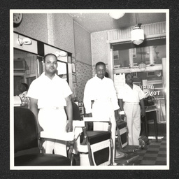 Three barbers pose inside of Burton's Tonsorial Parlor