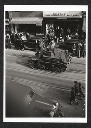 View of a tank driven by men participating in a defense parade