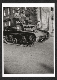 View of a tank driven by men participating in a defense parade