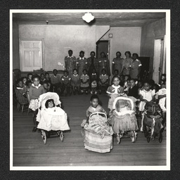 Children pose with teachers and toys