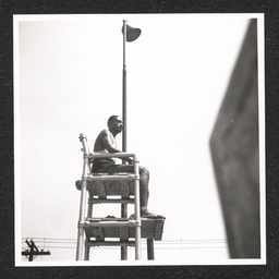 A lifeguard sits in a lifeguard chair