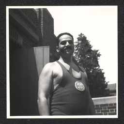 A lifeguard poses near a tree