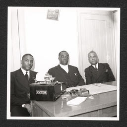 Three men sit at a desk in Bethel A.M.E. Church