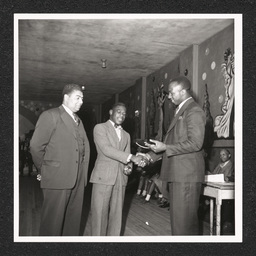 A student shakes hands while receiving an award at a school event