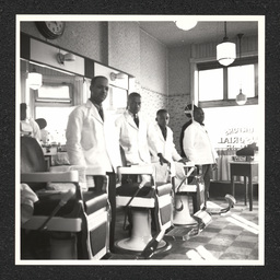 Four barbers pose by chairs at Burton's Tonsorial Parlor at 801 Walnut St. in Wilmington, Delaware.