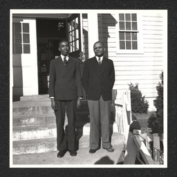 Teachers Matthew Coulbourne and Sylvester H. Woolford standing on the front steps of Buttonwood School