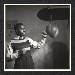 Young man using a punching bag at the Garrett Settlement House at 301 E. 7th St. in Wilmington, Delaware. During the Depression, settlement houses such as these provided families with food and shelter and acted as orphanages.