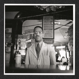 Dr. John L. Davidson, pharmacist, 9th St. Pharmacy, posing inside store, June, 1939