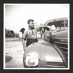 Texaco gas station, owner cleaning windshield, 1940