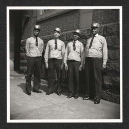 Pennsylvania Railroad Station, four porters pose outside, 1938-40