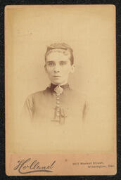 Carte de Visite showing the image of a woman with her watch pocket sewn over on her chest. The back of the card has information on the photography studio where the picture was taken.