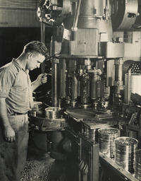 Man at work where cans are sealed, ca. 1950.