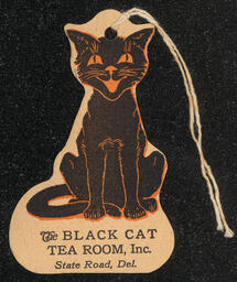 Hanging ornament in the shape of a black cat advertising The Black Cat Tea Room.