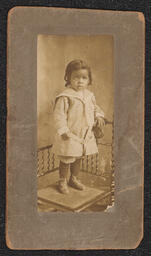 Photograph of a young child standing on a chair mounted on a gray frame. Embossed under the photograph is "A.N. Sanborn 404 Market St. Wilmington, Del.".