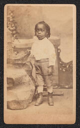Photograph, Child posing with rocks, front