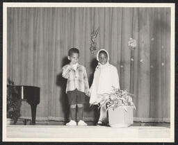 Two children on stage dressed for Easter, circa 1945-1965