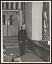 Rector of St. Michael's Day Nursery standing in auditorium