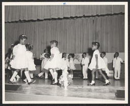 Group of girls performing on stage at St. Michael's Day Nursery.