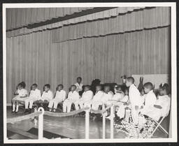 Group of children sitting on stage, circa 1945-1965
