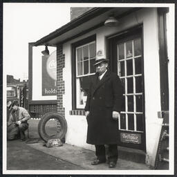 Full length shot of Fletcher G. White posing at door to White's Quick Service Station, 828 Walnut St., Wilmington, Feb 23 1938.