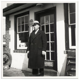 Full length shot of Fletcher G. White standing at door of White's Quick Service Station, 828 Walnut St., Wilmington, Feb 23 1938.