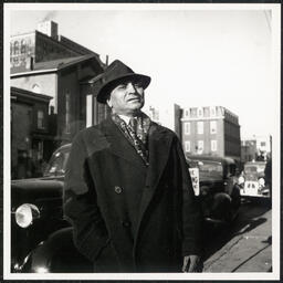 John O. Hopkins, manager of National Theater, posing in front of AUMP Church, French Street, December 4, 1938