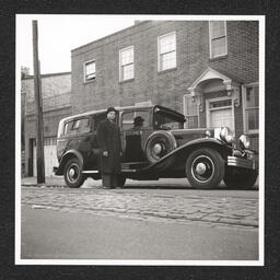 Edward LeMay Gray Funeral Home 722 Walnut St., poses next to car, February 4, 1939